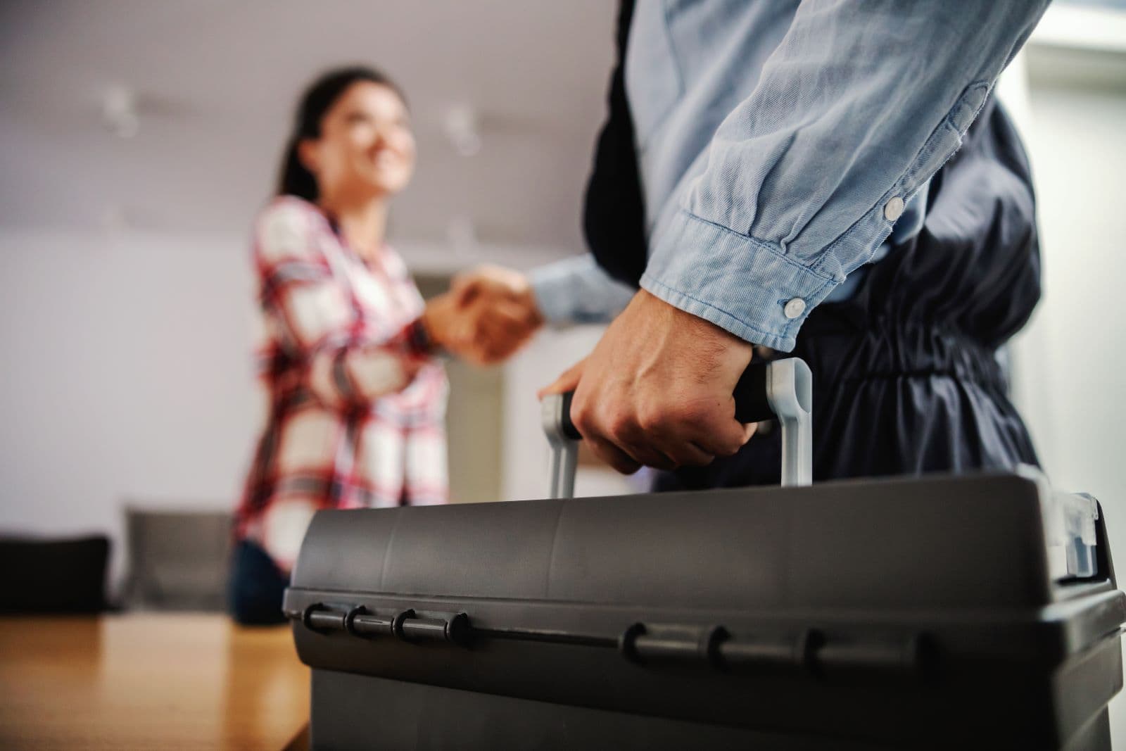 A woman shakes hands with a man holding a briefcase.
